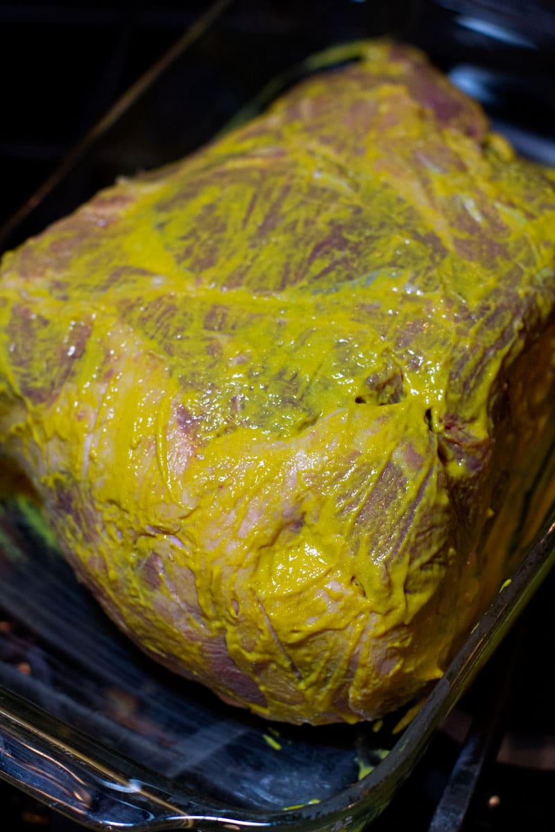 Pork shoulder basted in yellow mustard.