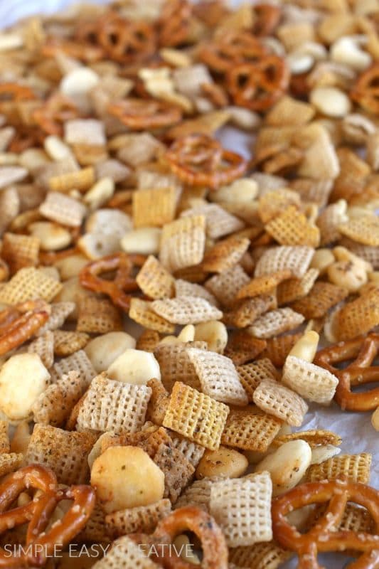 chex mix with pretzels and ranch seasoning on a baking sheet