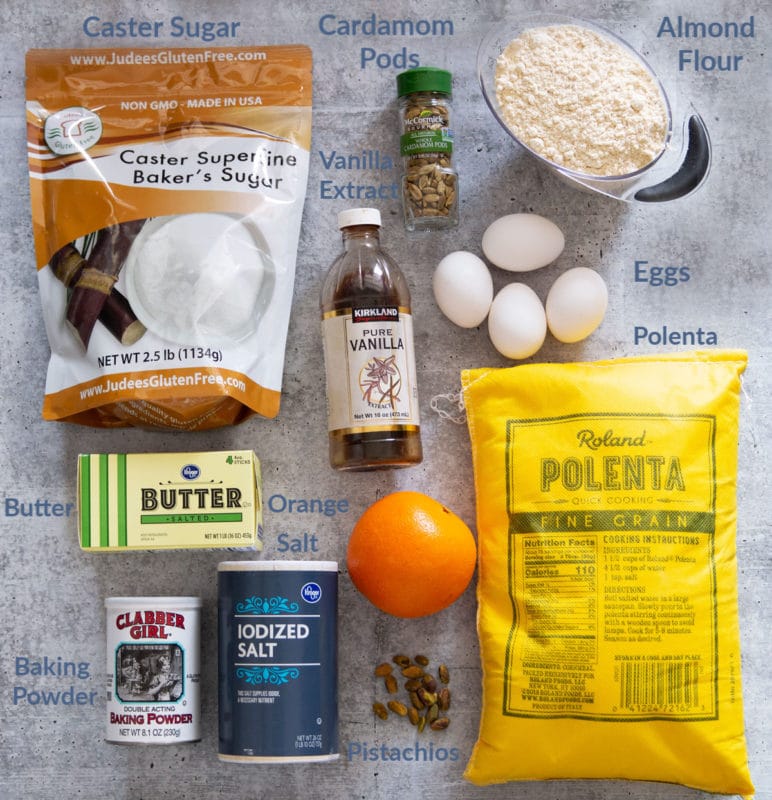 Caster sugar, almond flour, polenta, butter, salt, baking powder, eggs, vanilla, cardamom pods, and an orange.