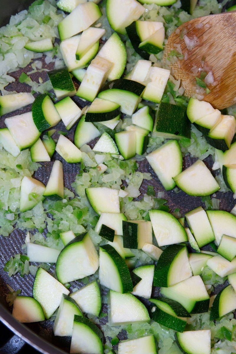 Sauteing fresh zucchini in a skillet. 