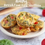 Egg muffins made with spinach, tomatoes, and egg on a plate.