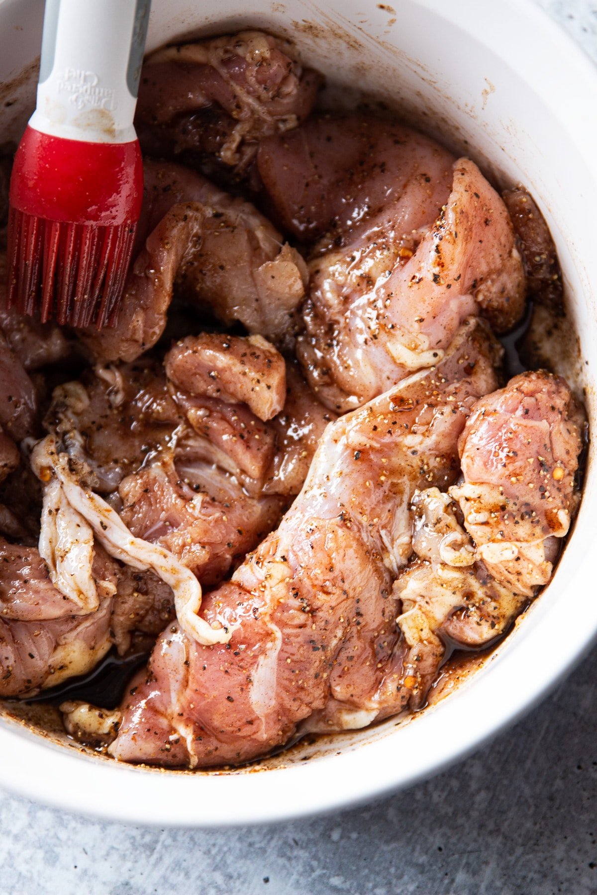 Bowl of marinated chicken thighs in asian marinade. 