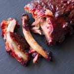 Baby back ribs falling off the bone, topped with BBQ sauce