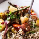 A fork full of smoked sausage, vegetables, and quinoa.