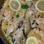 Chicken breasts cooked in a dutch oven topped with cream sauce.