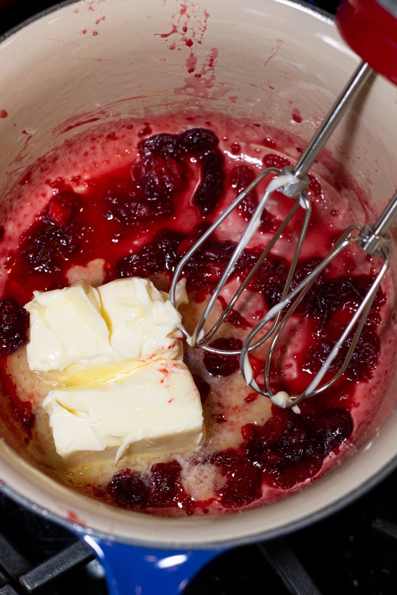 Electric mixer combining cranberry mixture to make a cranberry butter.