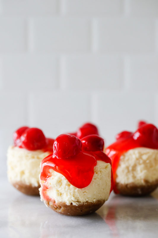 Mini cheesecake bites topped with cherry pie filling. 