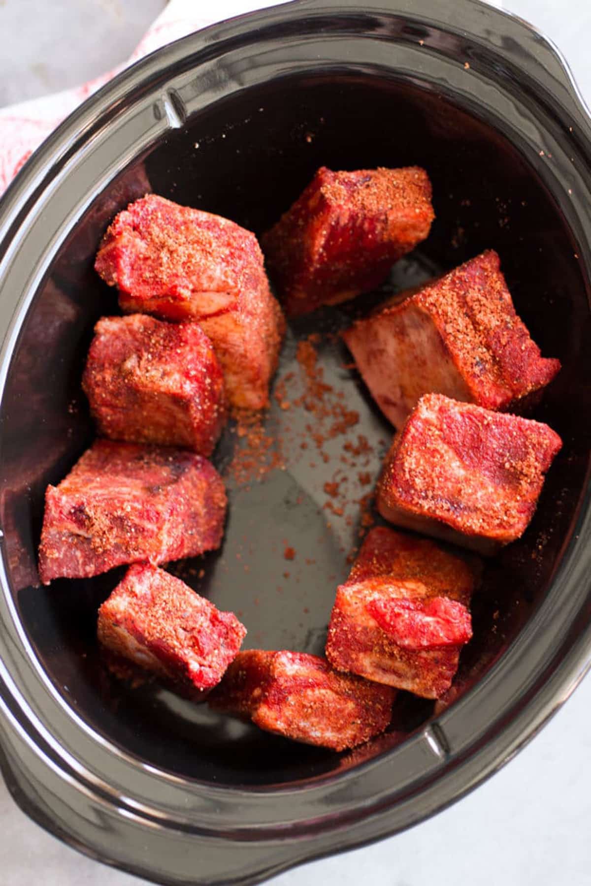 Seasoned short ribs in a crock pot. 