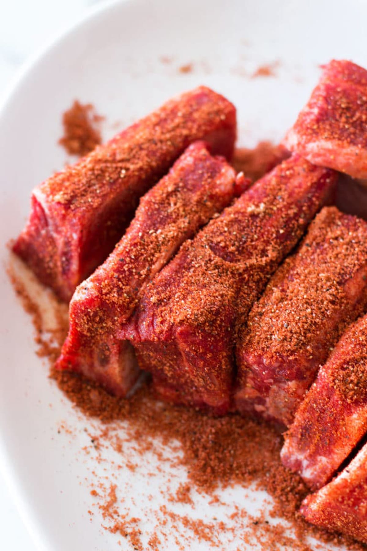 Dry rib rub covering beef short ribs.