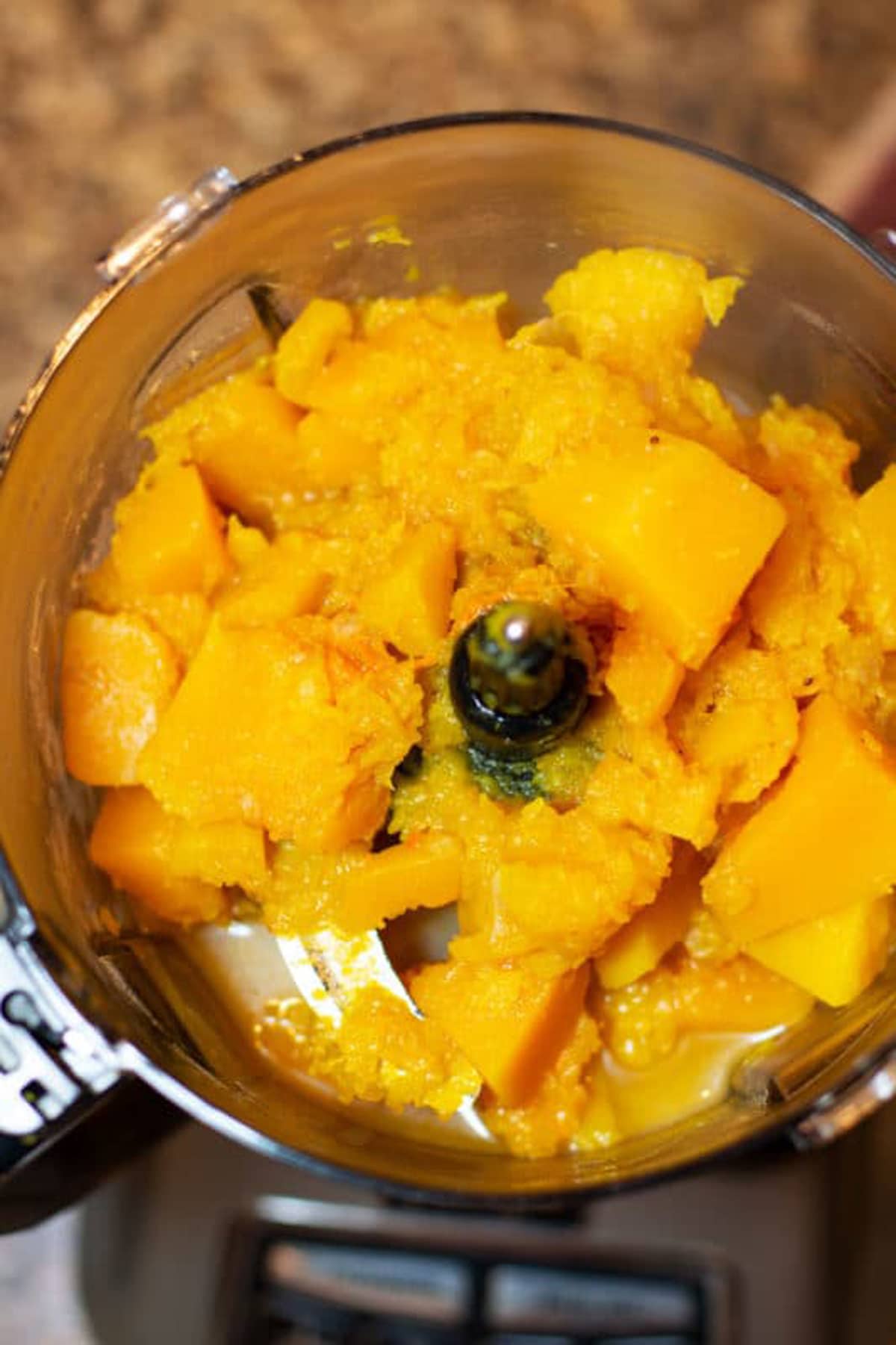 Cooked butternut squash in a food processor.