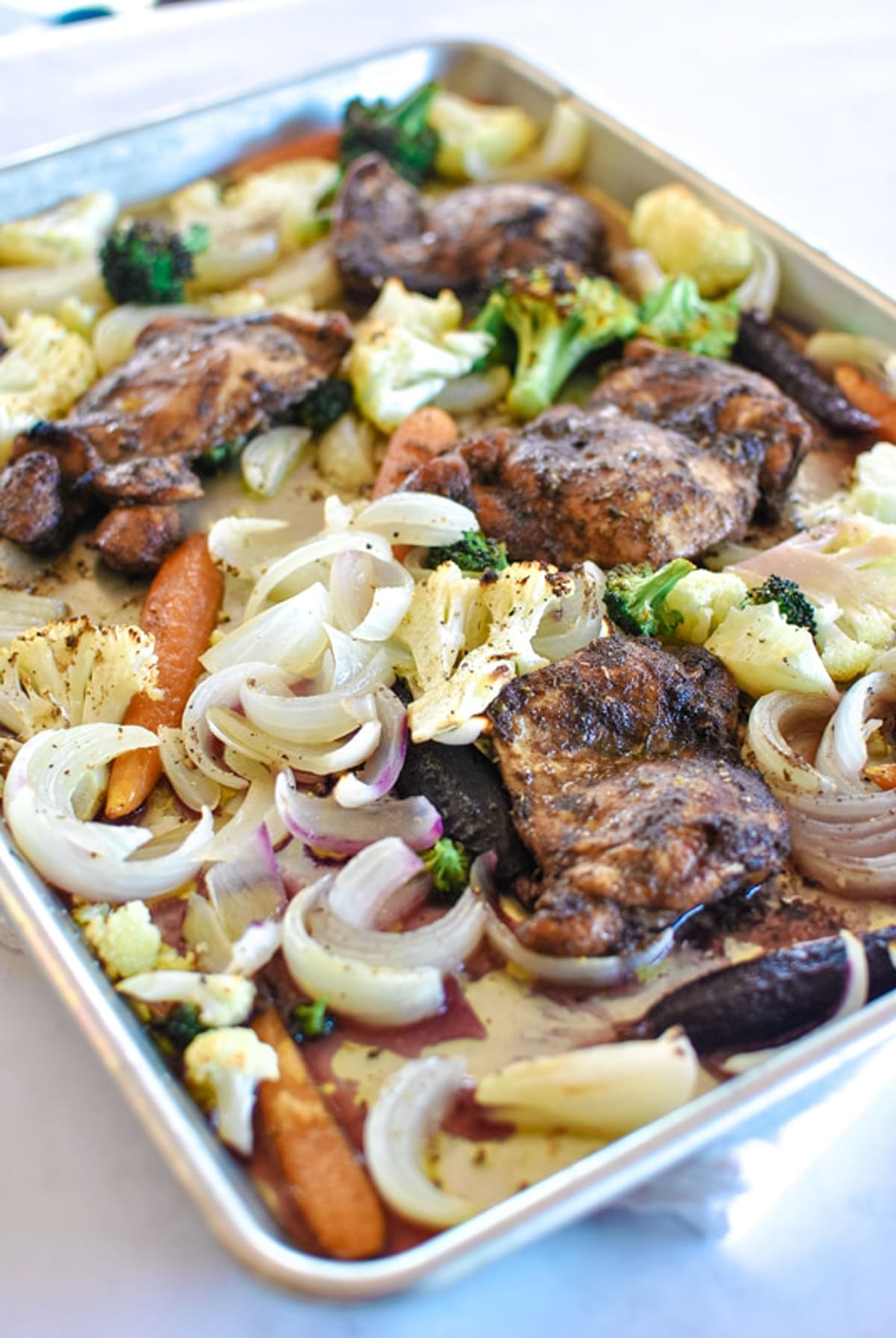 Baked chicken thighs recipe with vegetables for a sheet pan dinner.