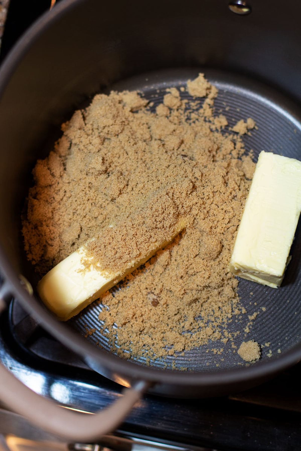 Pot containing brown sugar, margarine and butter for making a homemade caramel sauce.