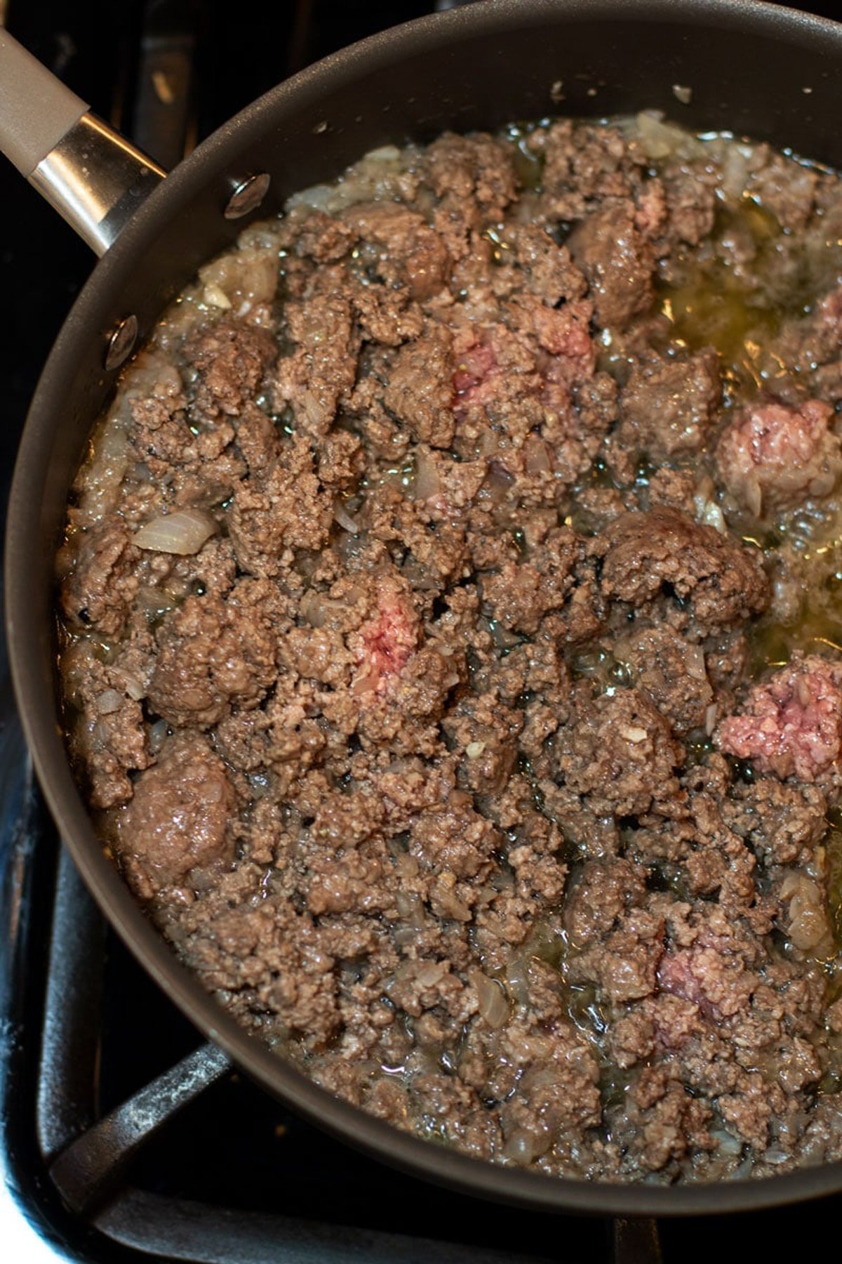 Ground beef and onions browning in a skillet.
