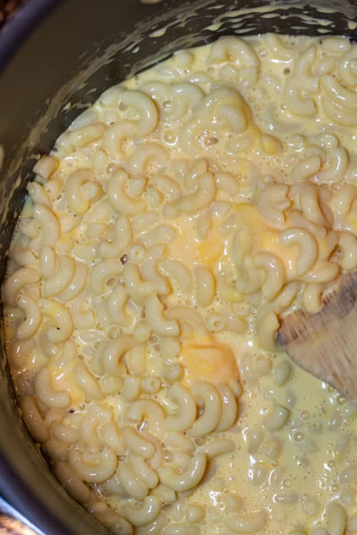 Pot of macaroni and cheese cooking on a stove top.