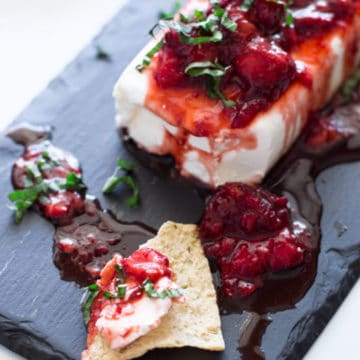 Cream cheese dip served on a pita chip topped with strawberry basil sauce.