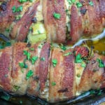 Bacon wrapped chicken stuffed with vegetables in cast iron skillet.