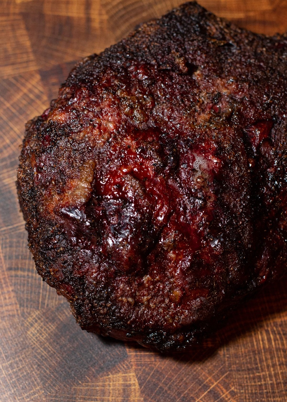 Whole smoked chuck roast sitting on cutting board. 