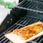 Maple Chipotle Grilled Salmon on a wood plank on a grill.