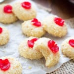 Cream Cheese cookies topped with cherries on a counter.
