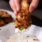 Pecan Crusted Chicken Tender being dipped in Ranch dipping sauce.