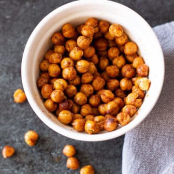 White bowl containing chili lime seasoned chickpeas on a black counter.