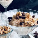 Cinnamon rice pudding (vegan) in martini glasses with walnuts and raisins.