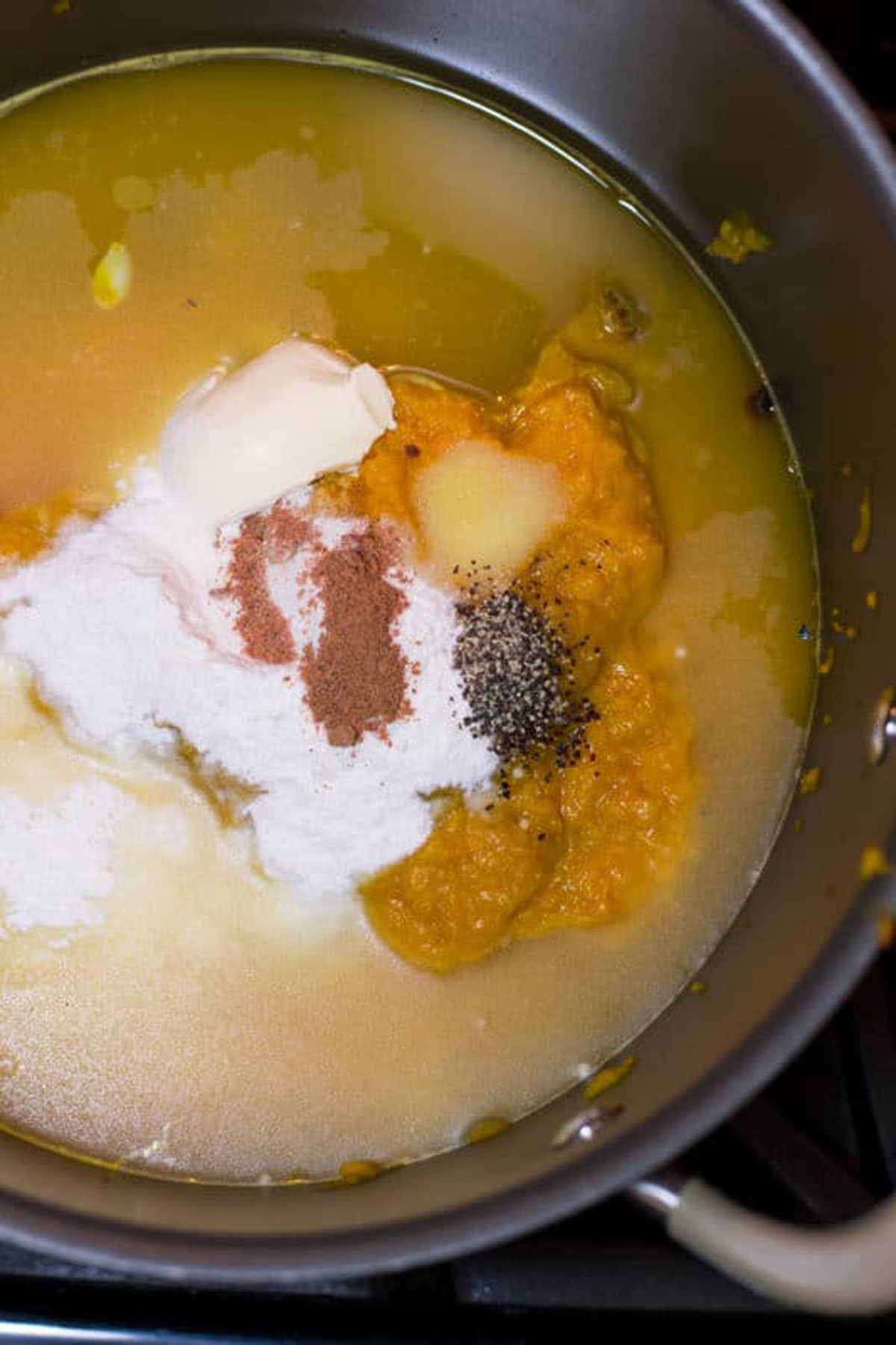 squash puree, rice flour, butter, nutmeg and water in a pot on the stove top.