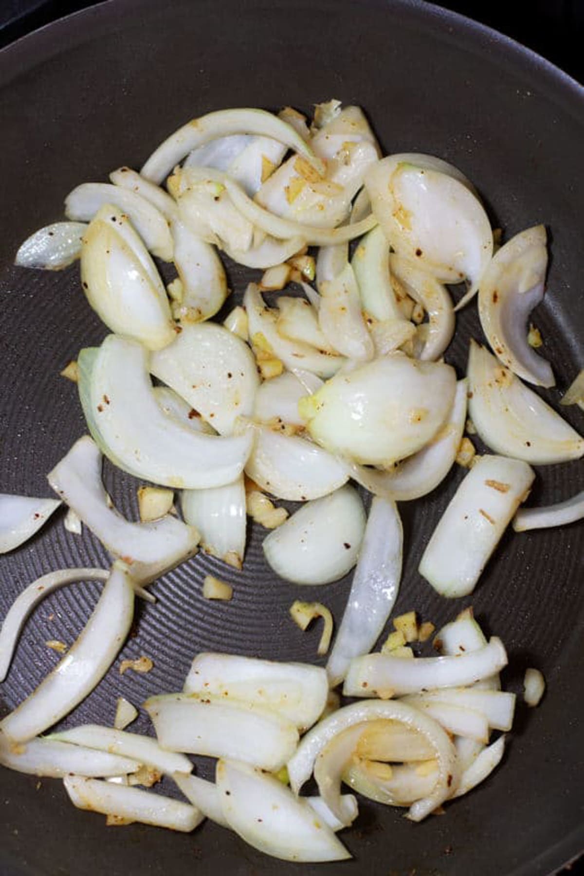 Sauteed onions and garlic in skillet on stovetop.