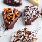 Shortbread cookies dipped in chocolate topped with pretzels and peppermint chips.
