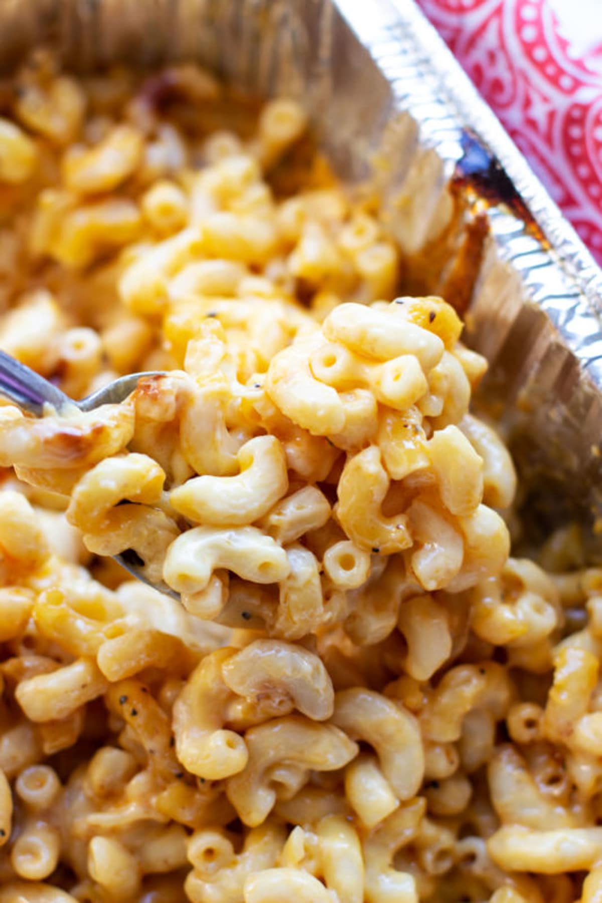 Spoonful of cooked Smoker Macaroni and Cheese in an aluminum pan.