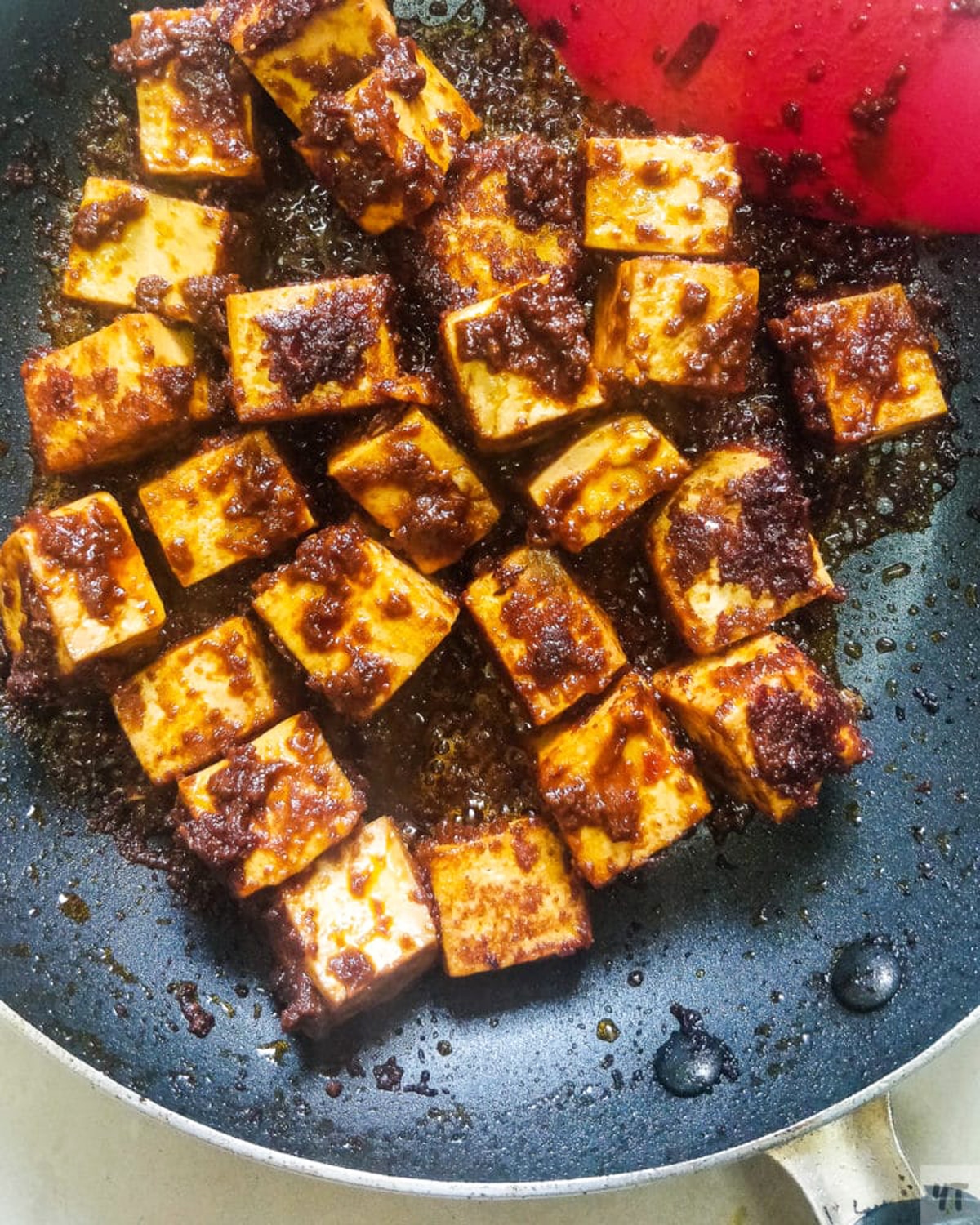 Caramelized tofu being sauteed in a skillet. 