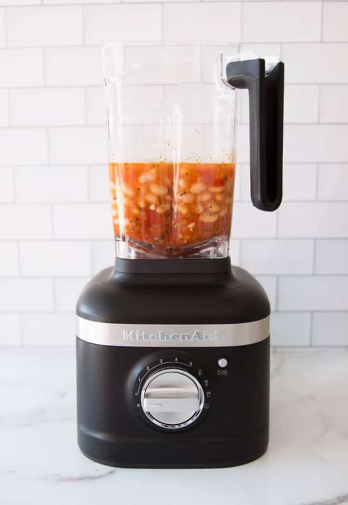 KitchenAid blender containing white beans and tomato juice.
