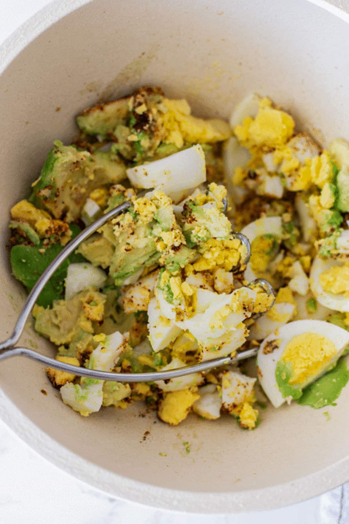 Mashed eggs, avocado and spices to make Avocado Egg Salad.