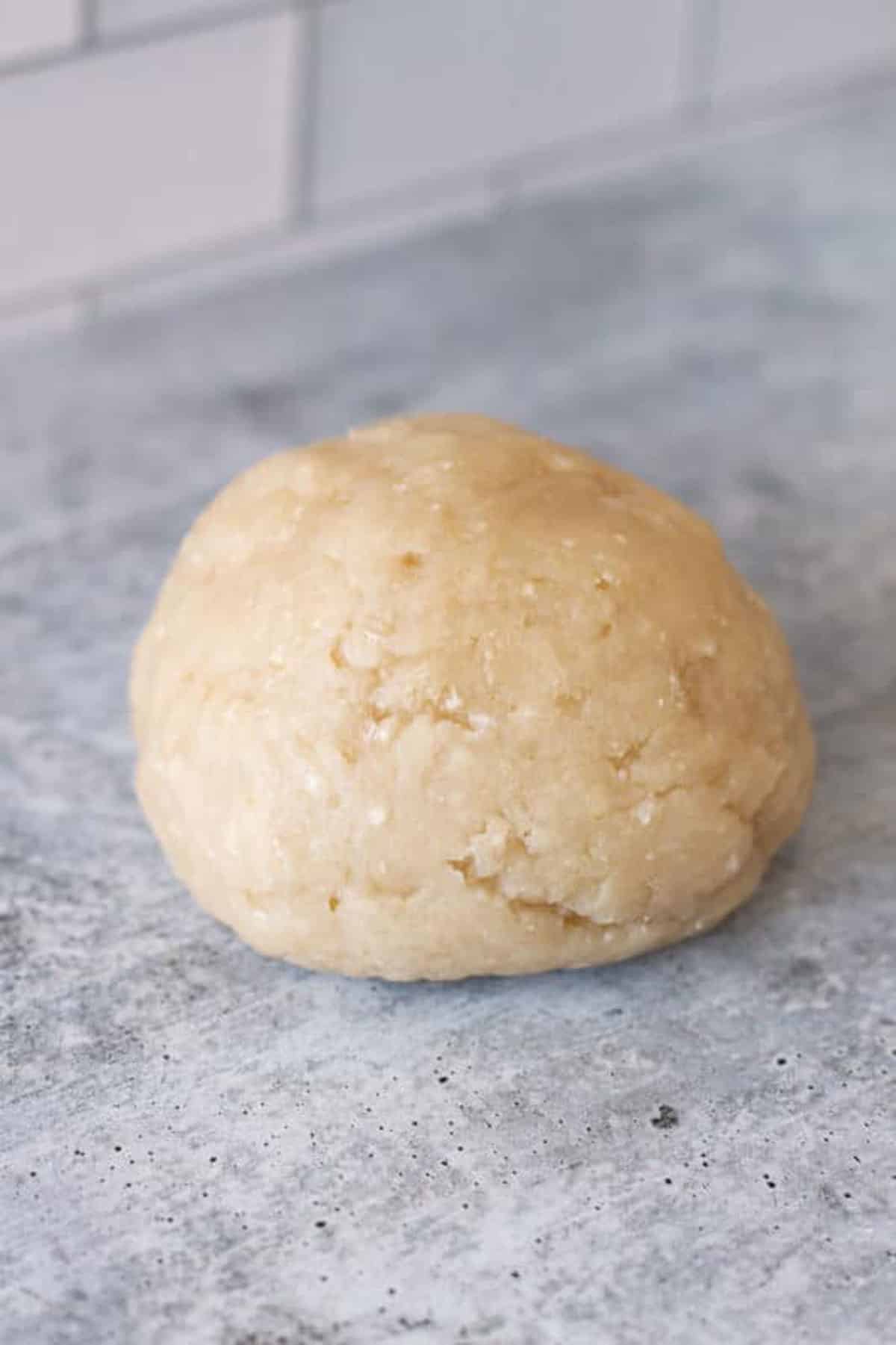 Churro dough in a ball sitting on a countertop.