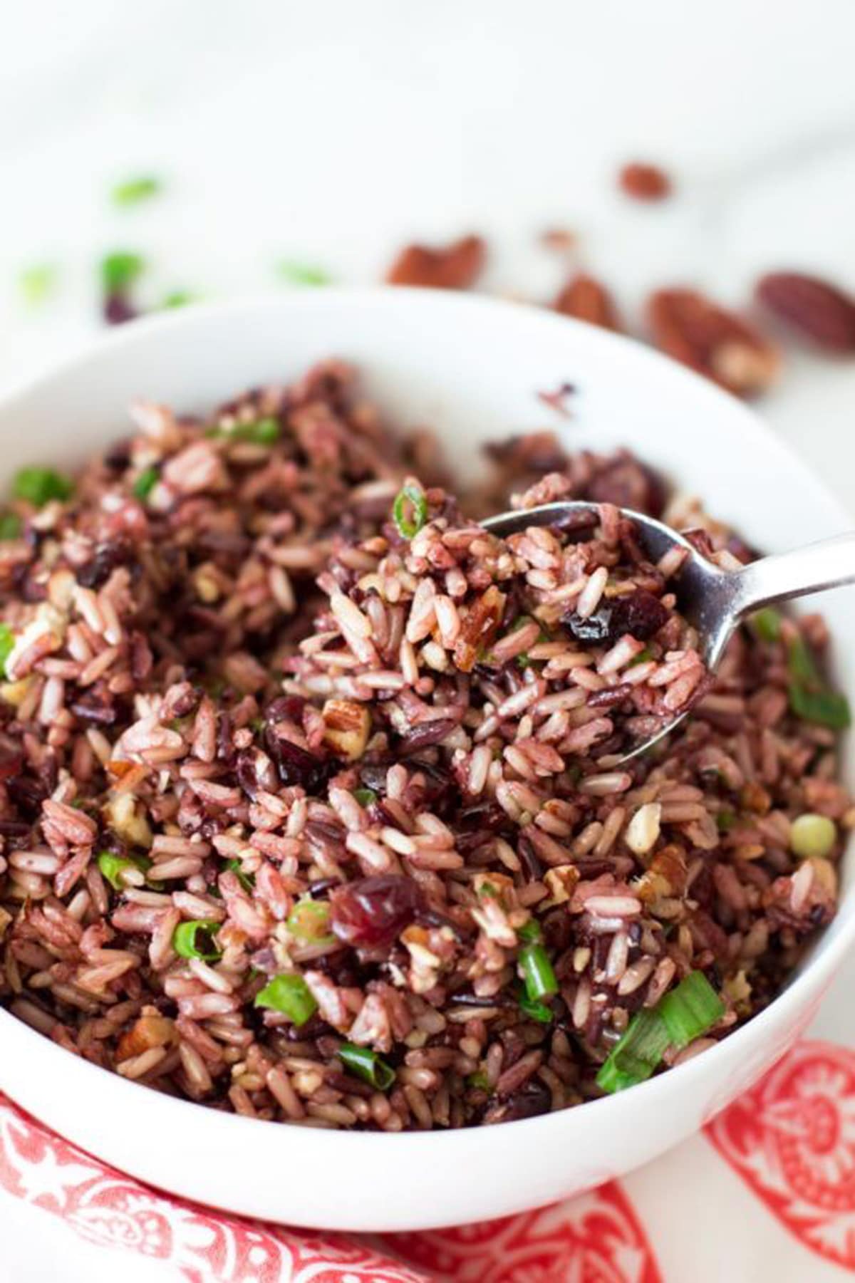 Spoonful of brown and wild rice topped with scallions.
