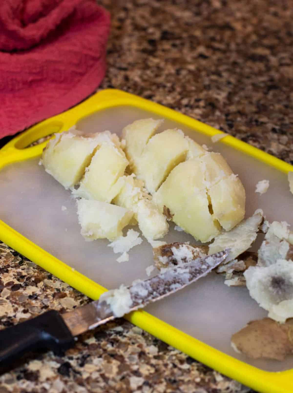 Dicing a potato on cutting board.