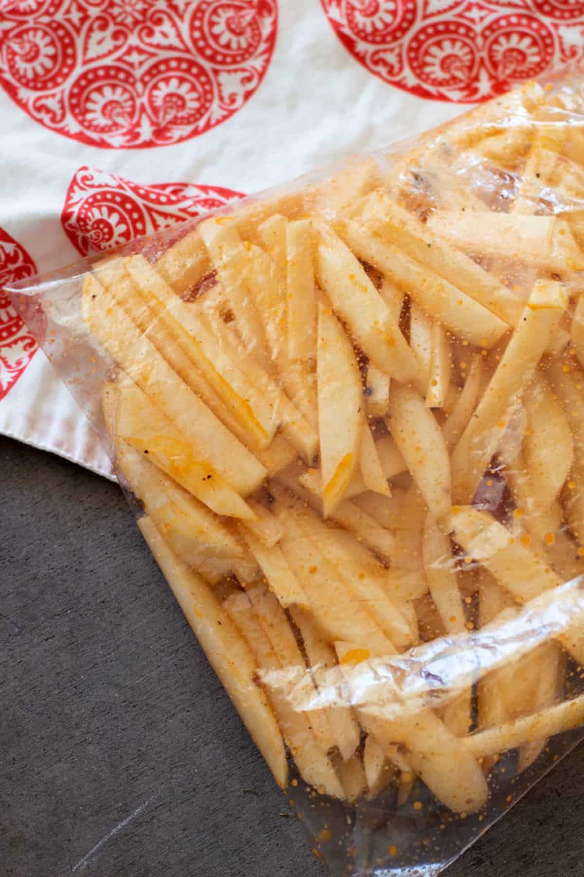 Ziplock bag filled with cut potatoes and seasonings to make air fryer french fries. 