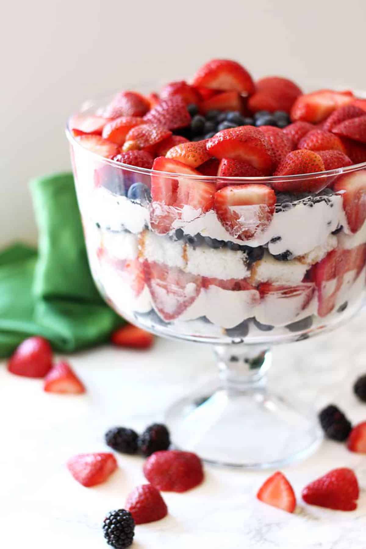 Strawberries, Blueberries and angel food cake with a whipped cream cheesecake filling in a trifle bowl.