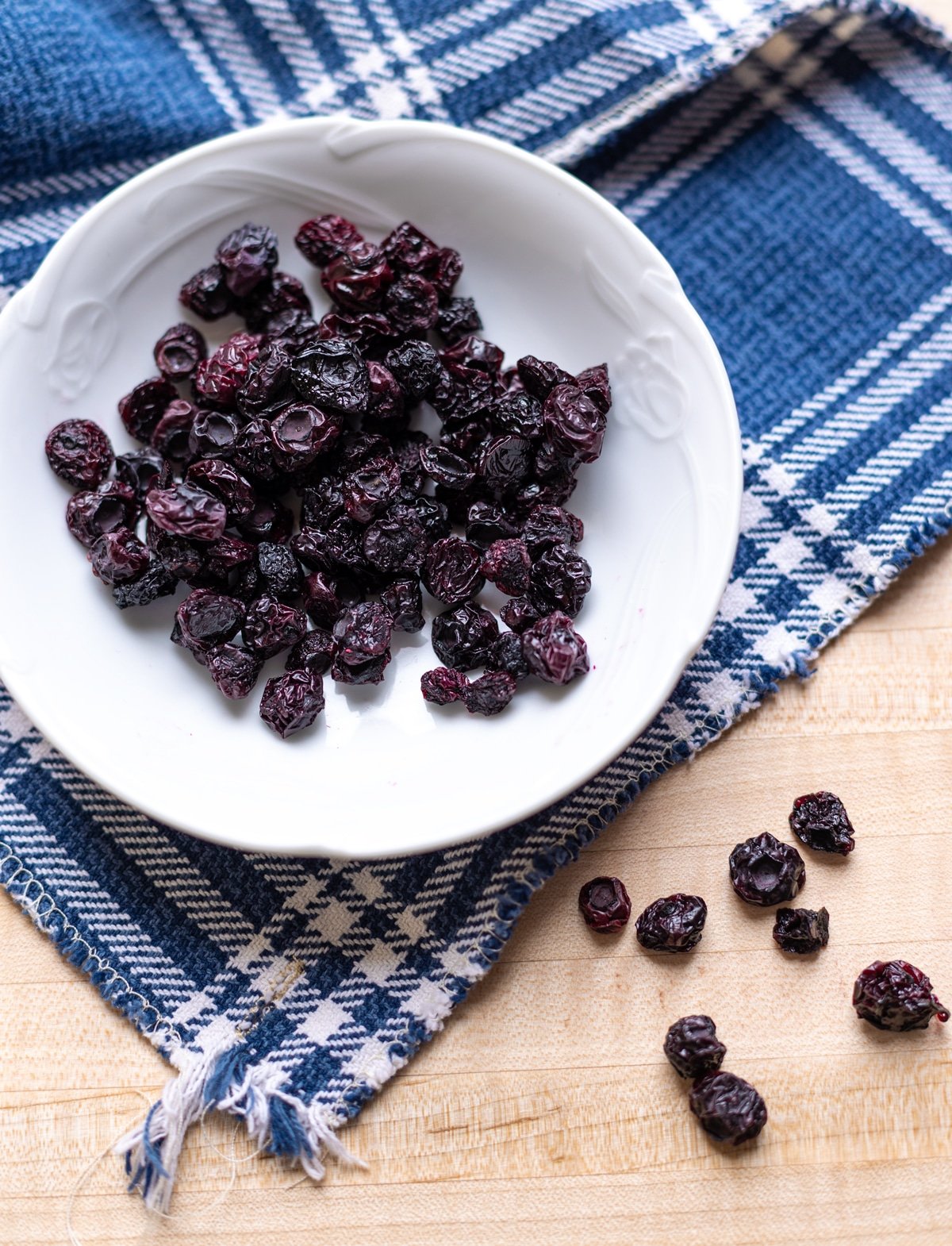 Dehydrated blueberries on the counter, spoon filled with berries.