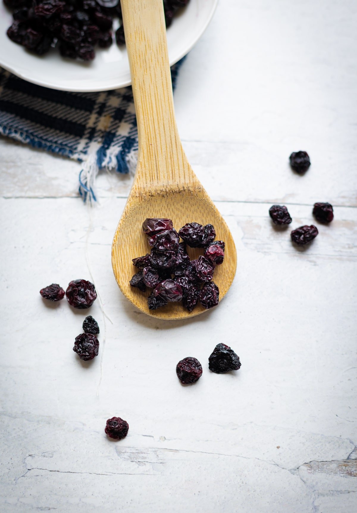 Wooden spoon filled with dried blueberries. 