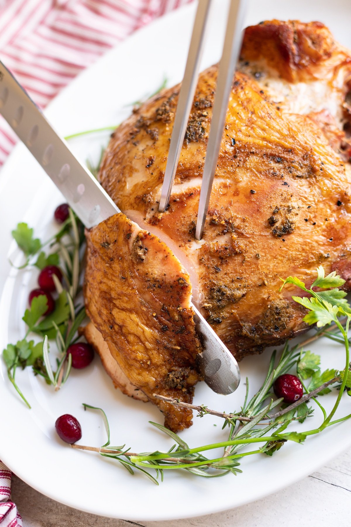 Person using a carving knife to slice a turkey breast.