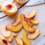 Sliced fresh peaches on a cutting board.