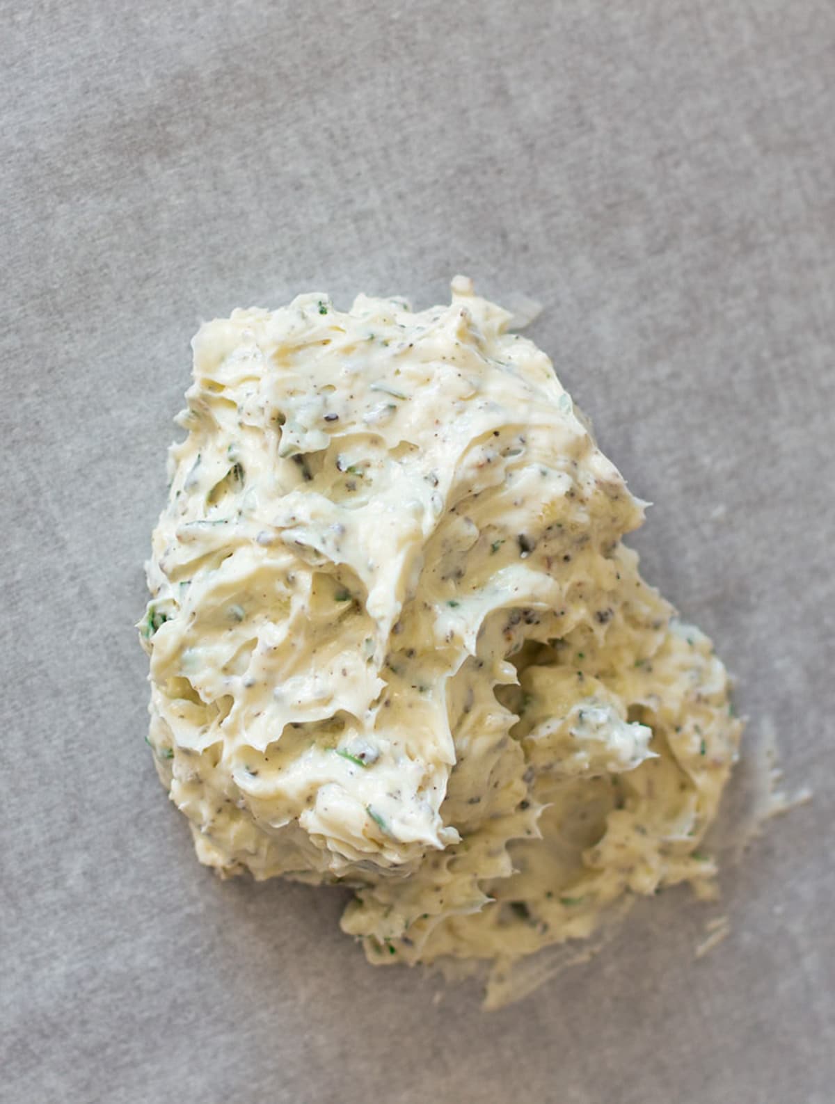 Dollop of herb compound butter on parchment paper.