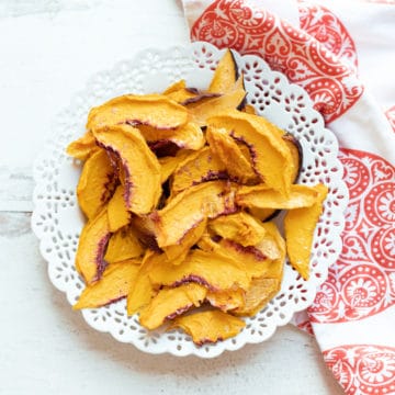 White plate containing dried sliced peaches.
