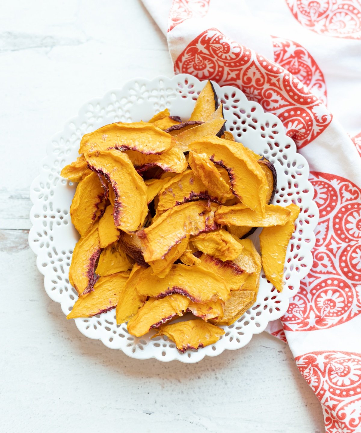 White plate containing dried sliced peaches. 