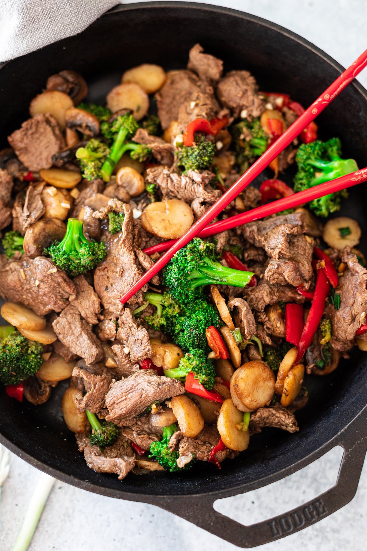 Skillet containing beef and vegetable stir fry, chopsticks in a skillet. 