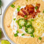 A white chicken chili keto recipe topped with bacon and jalapenos.