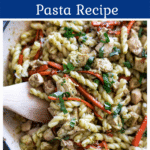 Closeup of a plate of pesto pasta with chicken.