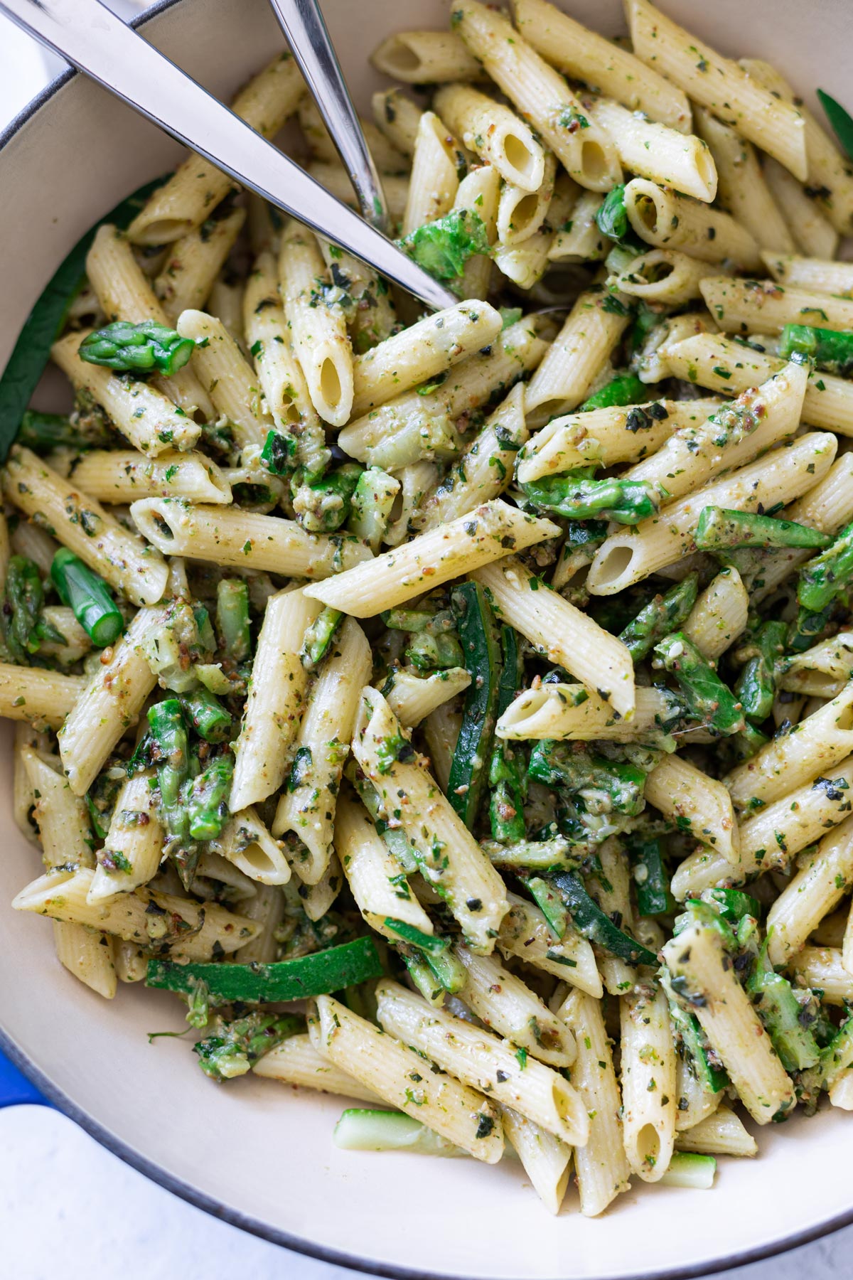 Close up of pesto penne pasta with asparagus and zucchini. 