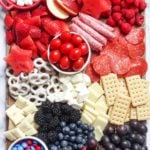 Memorial day charcuterie board filled with fruit, candy, cheese, and meats.